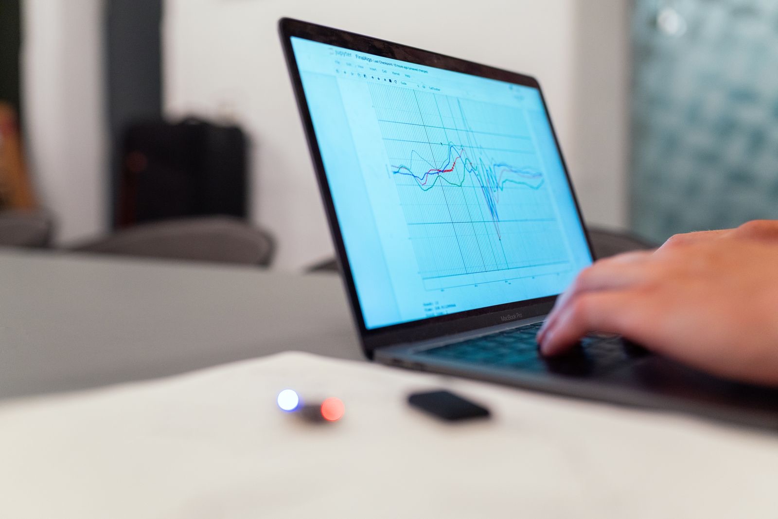 Laptop on a desk displaying a line chart of analytics data