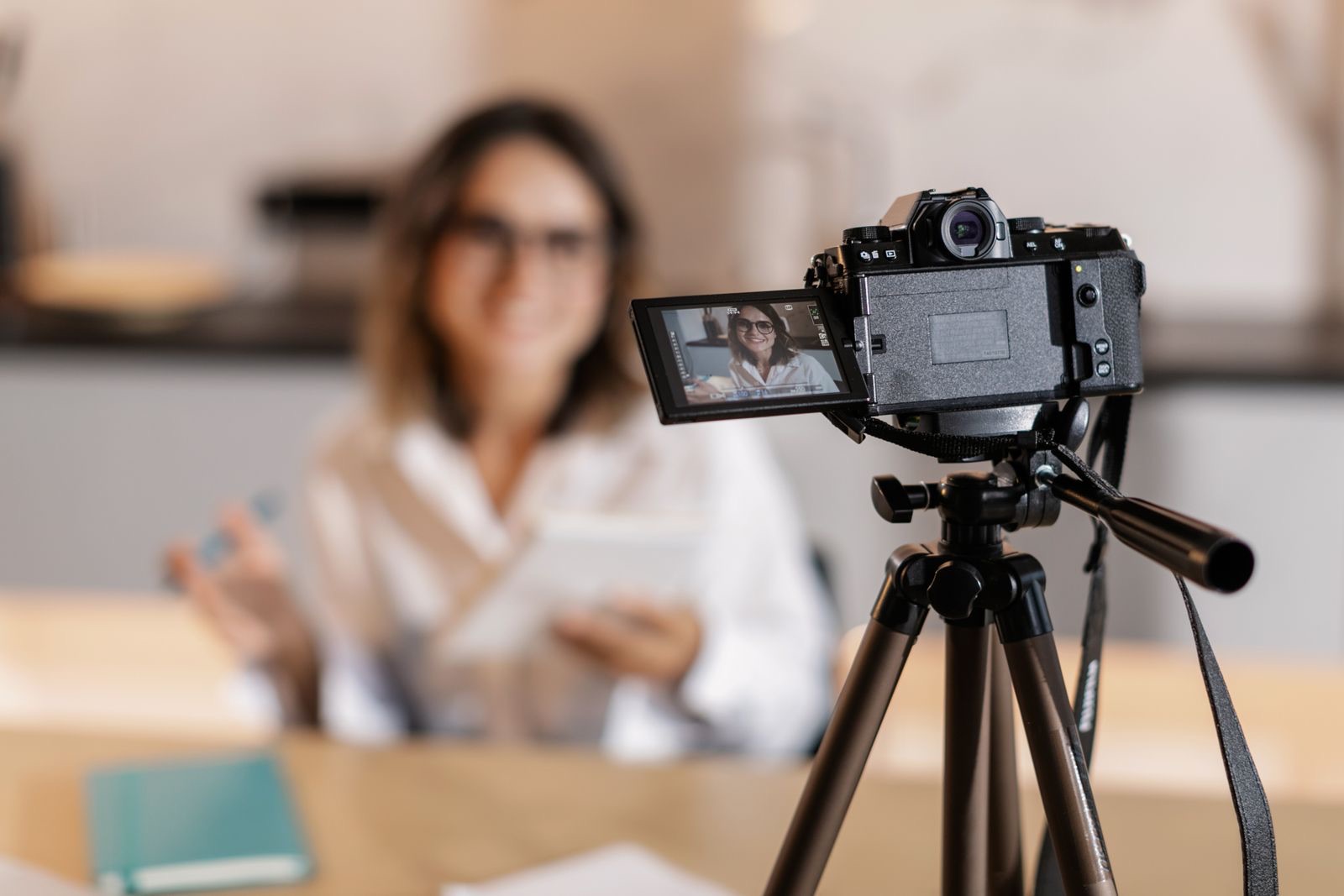 Camera on a tripod filming a content creator during a video shoot