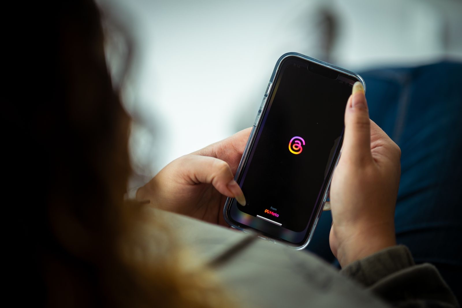 Person holding a phone and opening a social app to check their feed